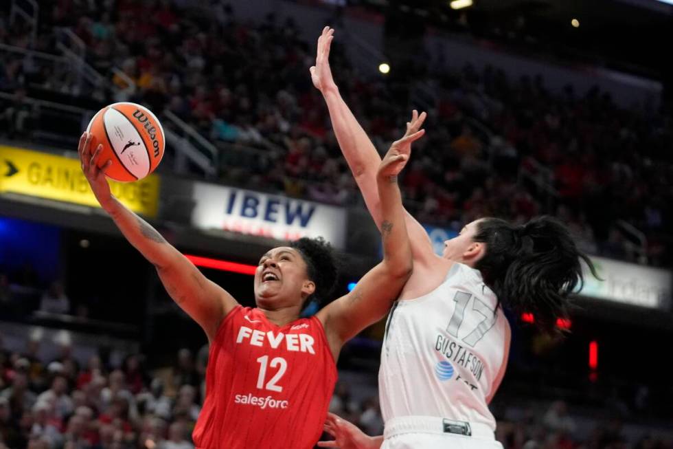 Indiana Fever's Damiris Dantas (12) shoots against Las Vegas Aces' Megan Gustafson (17) during ...