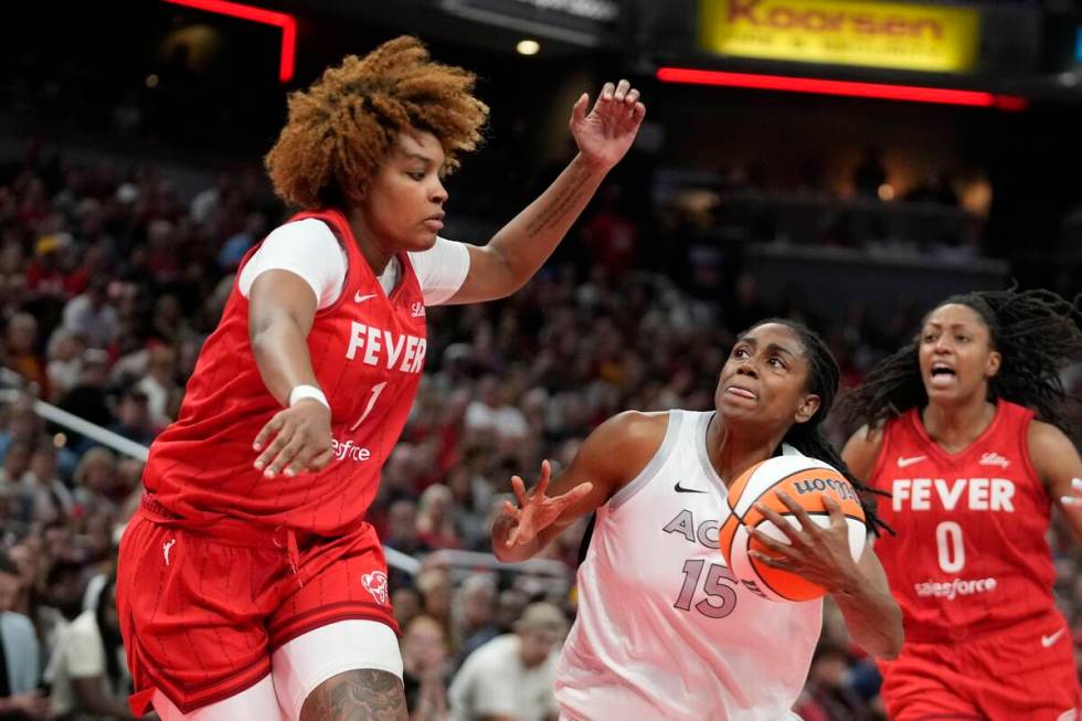 Las Vegas Aces' Tiffany Hayes (15 goes to the basket against Indiana Fever's NaLyssa Smith (1) ...