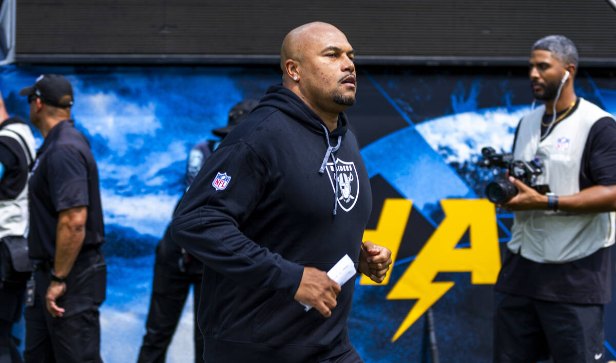 Raiders head coach Antonio Pierce runs out of the tunnel to face the Los Angeles Chargers for t ...