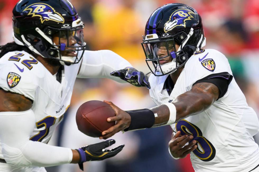 Baltimore Ravens quarterback Lamar Jackson (8) hands off to Baltimore Ravens running back Derri ...