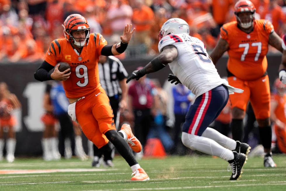 Cincinnati Bengals quarterback Joe Burrow (9) runs from New England Patriots linebacker Ja'Whau ...