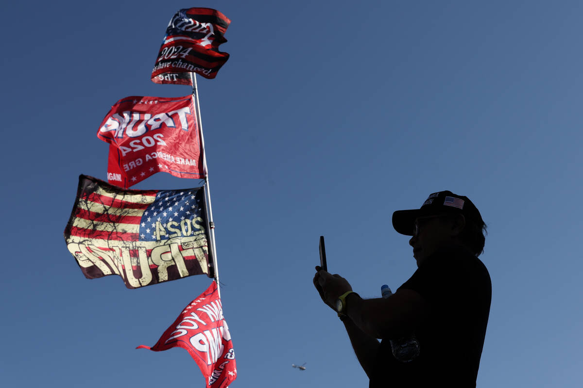 A supporter of former US President and Republican presidential candidate Donald Trump pauses to ...