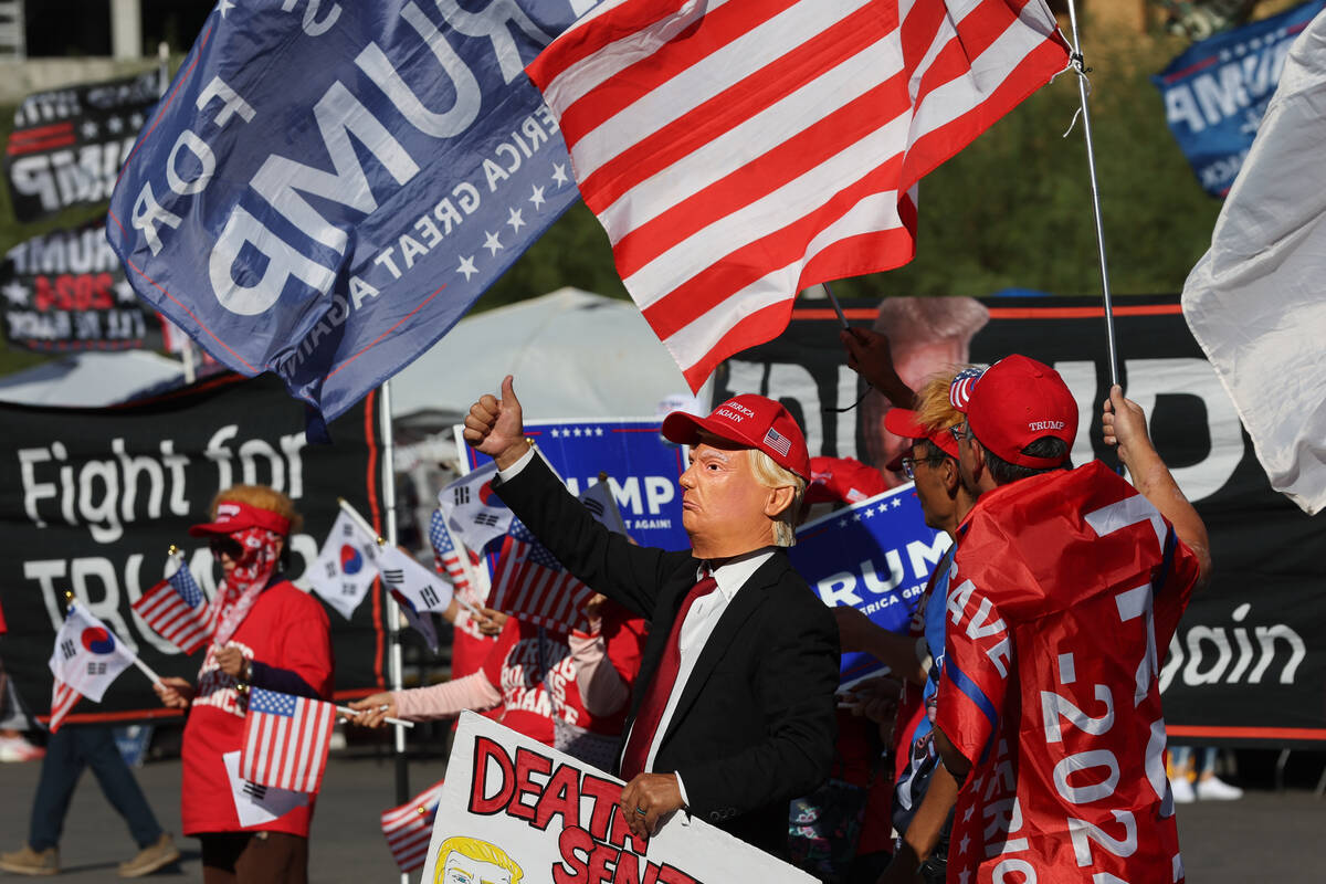 Supporters of former US President and Republican presidential candidate Donald Trump wave flags ...