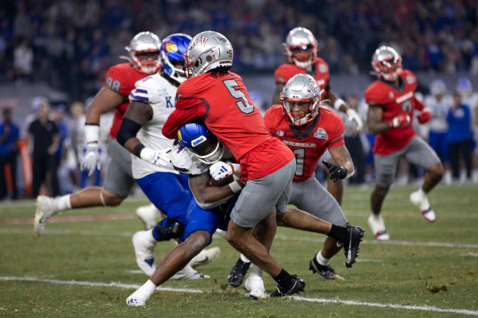 Kansas Jayhawks running back Devin Neal (4) collides with UNLV Rebels running back Vincent Davi ...