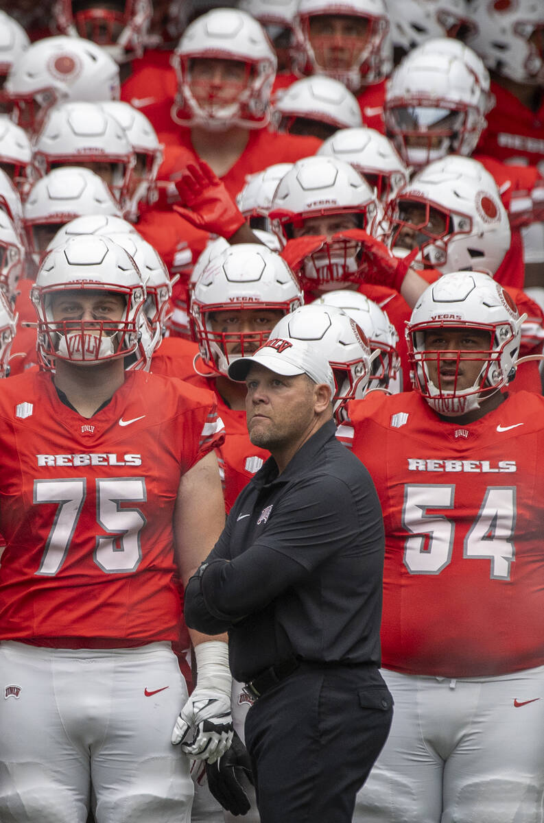 UNLV head coach Barry Odom and the rest of the team wait to take the field before the college f ...