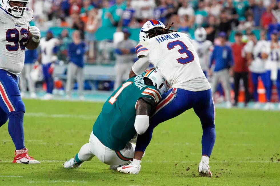 Miami Dolphins quarterback Tua Tagovailoa (1) collides with Buffalo Bills safety Damar Hamlin ( ...