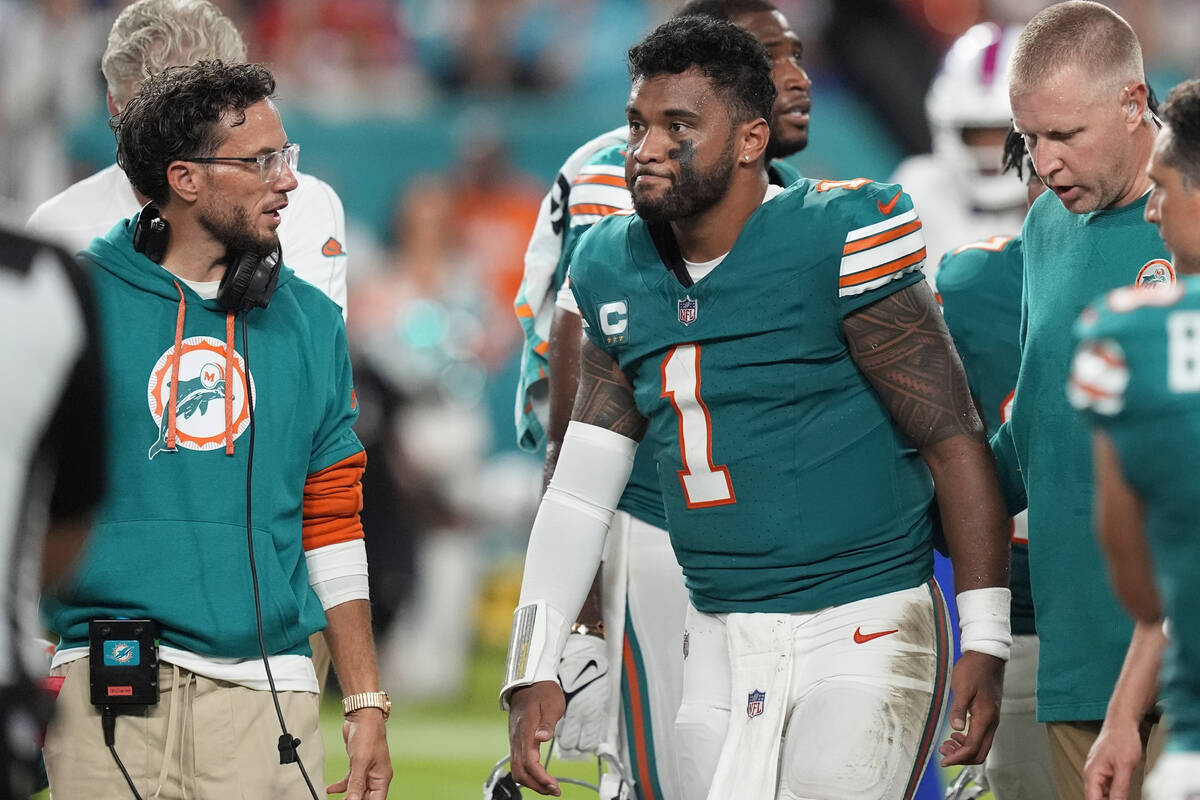 Miami Dolphins head coach Mike McDaniel talks to quarterback Tua Tagovailoa (1) as he leaves th ...