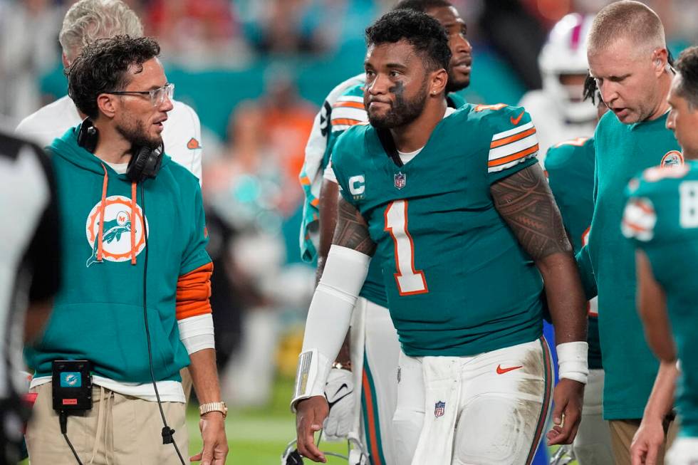 Miami Dolphins head coach Mike McDaniel talks to quarterback Tua Tagovailoa (1) as he leaves th ...