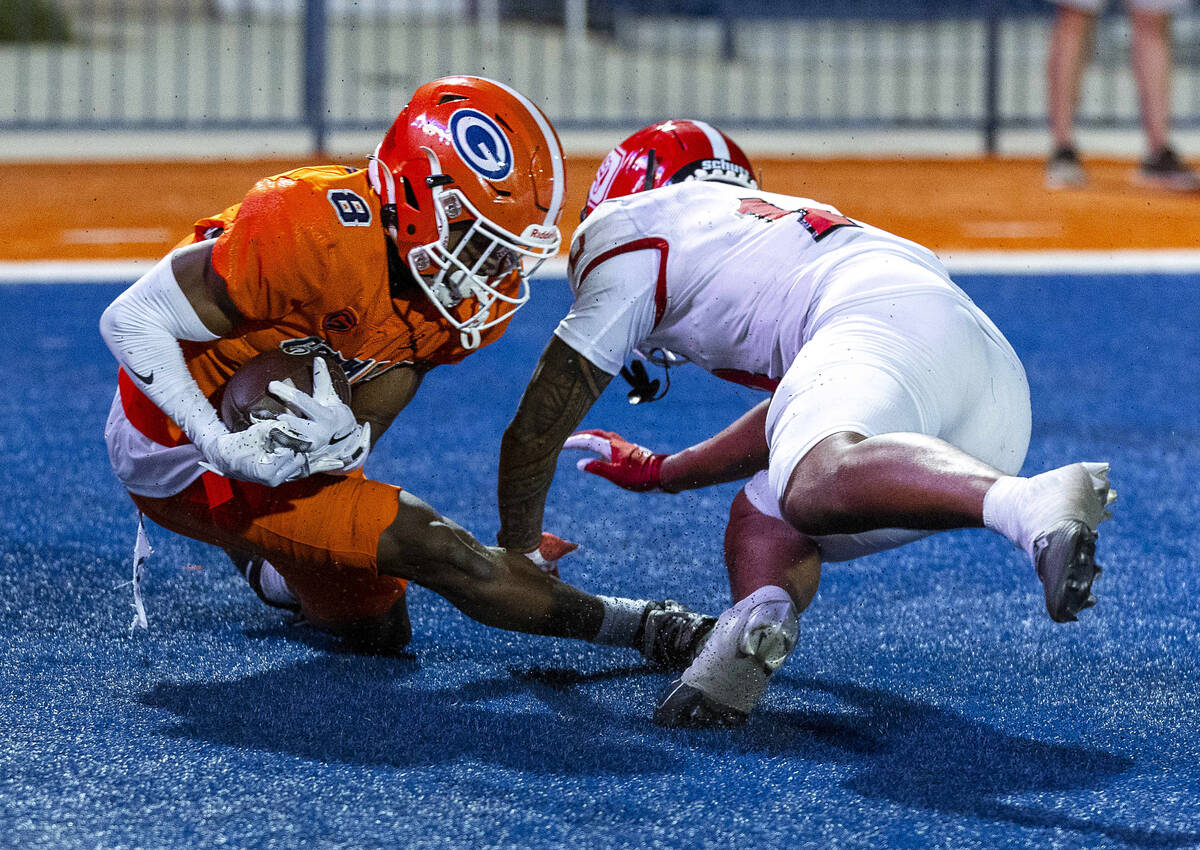 Bishop Gorman wide receiver Greg Toler (8) secures a touchdown pass over Orange Lutheran defens ...