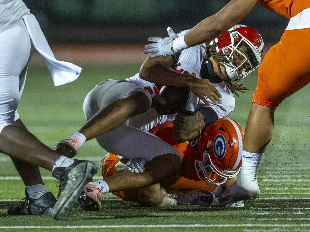 Orange Lutheran quarterback Tj Lateef (9) is tackled by Bishop Gorman linebacker Aksel Ferry (2 ...