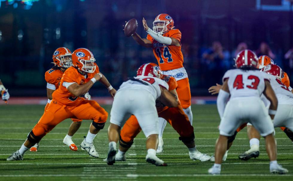 Bishop Gorman quarterback Maika Eugenio (14) reaches for an errant snap against Orange Lutheran ...