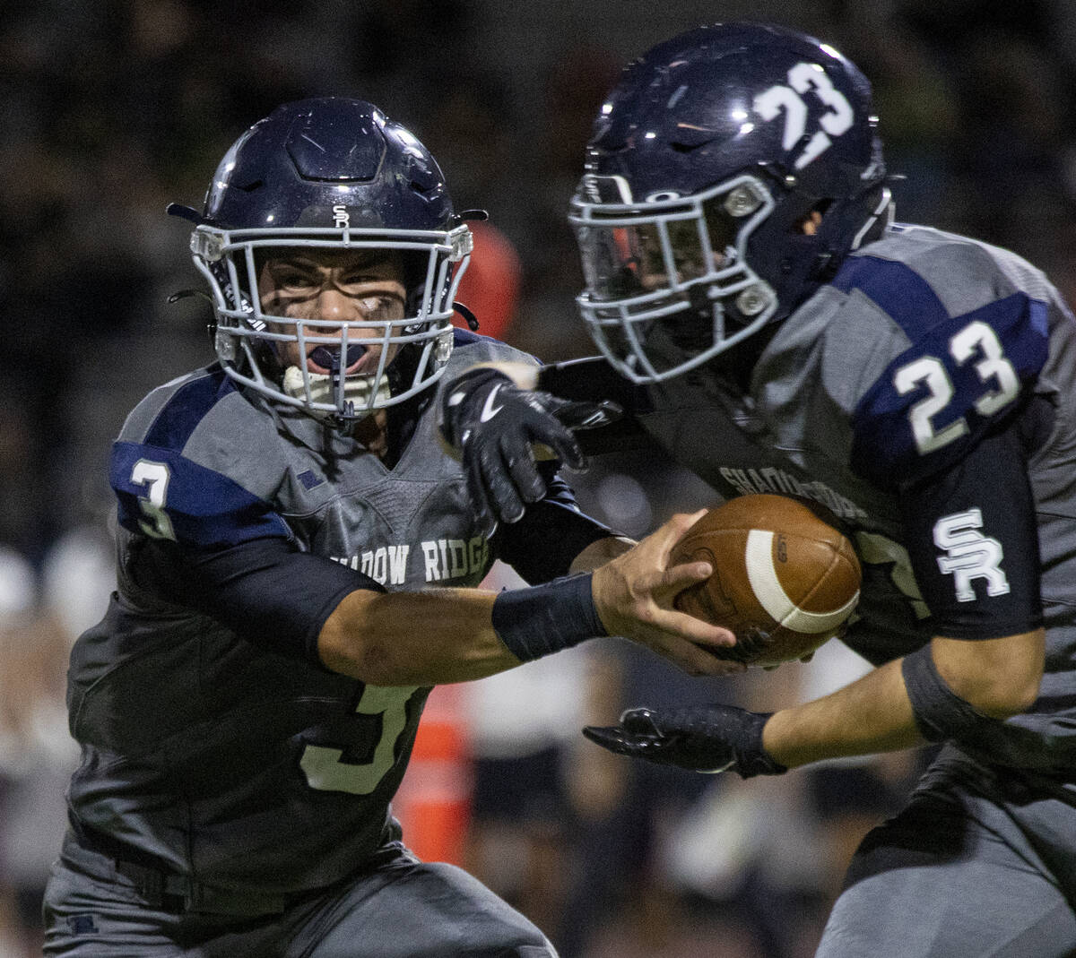 Shadow Ridge quarterback Ula Cox (3) hands the ball to junior Hector Velazquez (23) during the ...