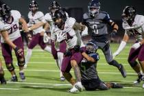 Shadow Ridge sophomore Isaiah Ruiz (5) attempts to tackle Faith Lutheran senior Cale Breslin (1 ...