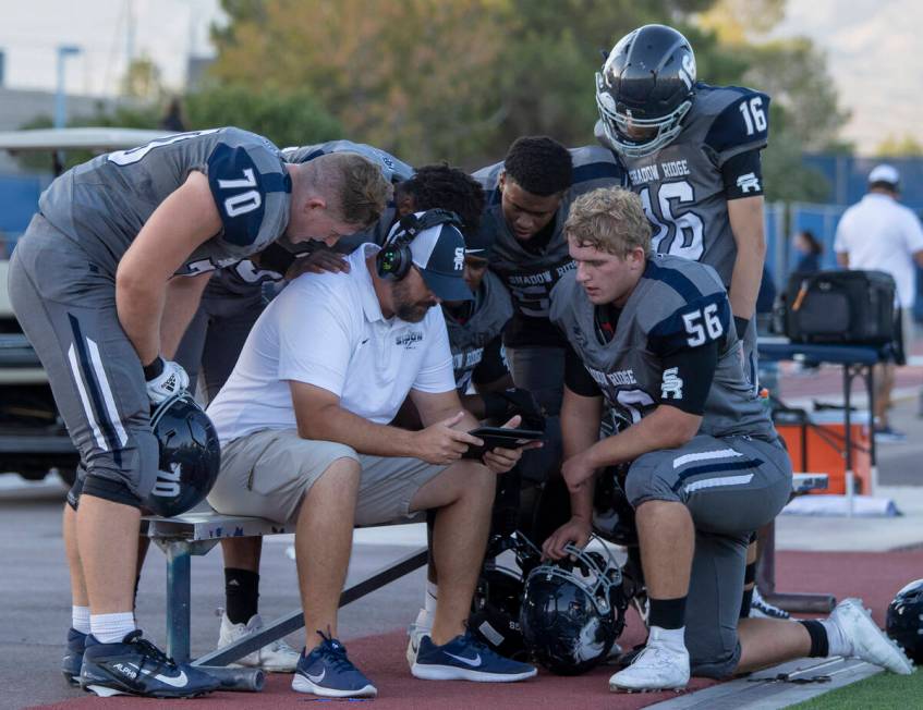 Shadow Ridge players watch film along the sideline during the high school football game against ...