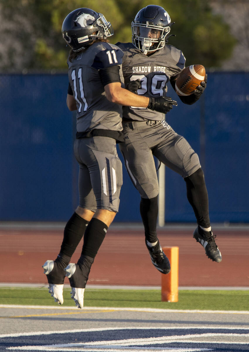 Shadow Ridge senior Joseph Darr (11) and junior Trevin Young (29) celebrate a touchdown during ...