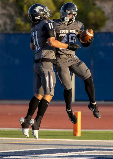 Shadow Ridge senior Joseph Darr (11) and junior Trevin Young (29) celebrate a touchdown during ...