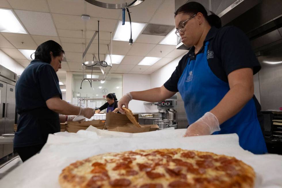 Cafeteria workers prepare pizza for student lunches at Firebaugh High School in Lynwood, Calif. ...