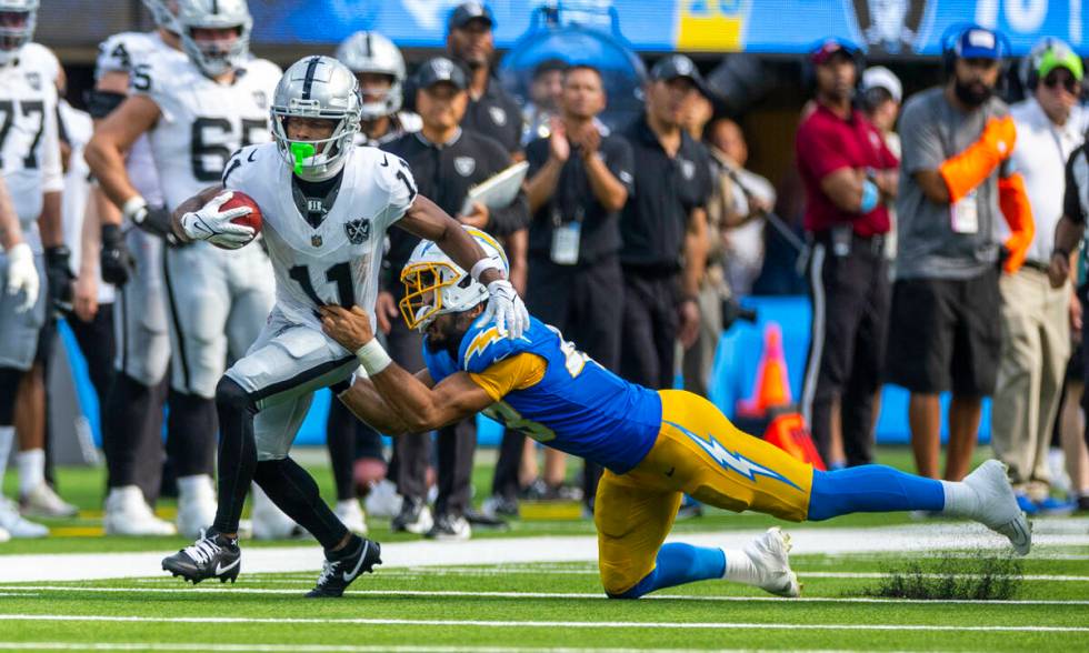 Raiders wide receiver Tre Tucker (11) looks to beat a tackle attempt by Los Angeles Chargers li ...