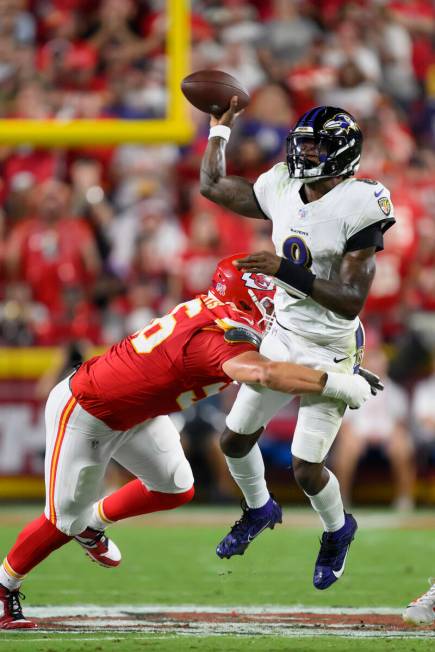 Baltimore Ravens quarterback Lamar Jackson (8) is hit by Kansas City Chiefs defensive end Georg ...