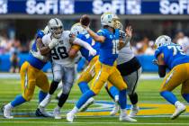 Raiders defensive end Maxx Crosby (98) is held while rushing to get to Los Angeles Chargers qua ...