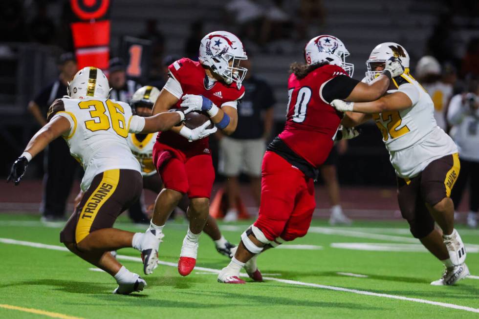 Liberty running back Ezra Sanelivi (1) runs the ball through a pocket of players during a Ninth ...