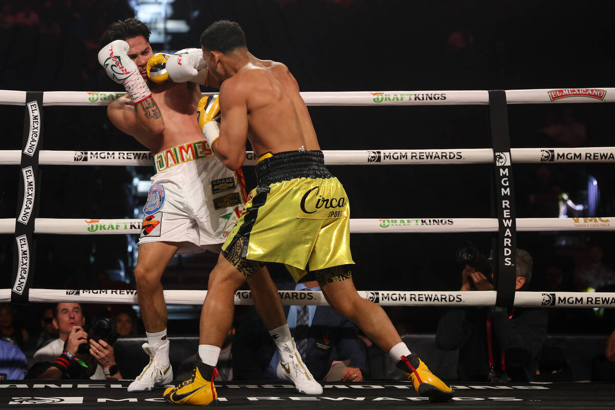 Rolly Romero, right, gets a right on Manuel Jaimes during a super lightweight boxing bout at T- ...