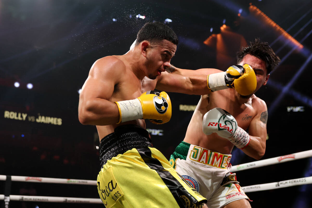 Rolly Romero, left, gets a left on Manuel Jaimes during a super lightweight boxing bout at T-Mo ...