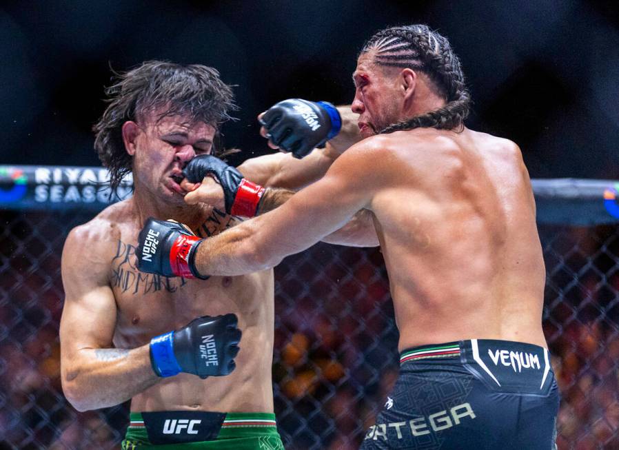 Featherweight Diego Lopes takes a punch to the face from Brian Ortega in their fight during UFC ...