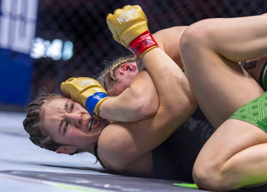 Women's flyweight title fighter Alexa Grasso gets a glove to the face as she holds the head of ...