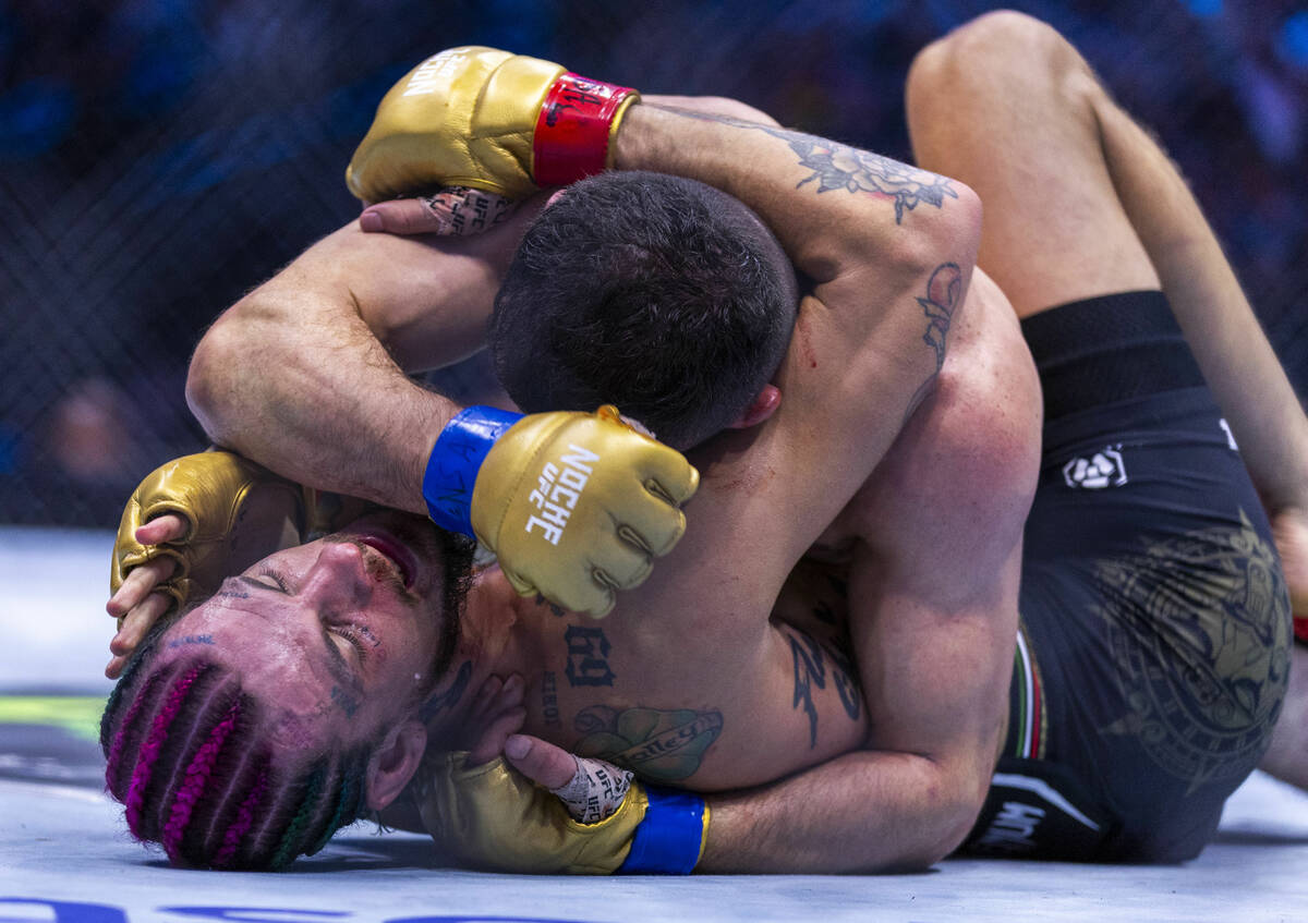 Sean O'Malley gets a forearm to the face by Merab Dvalishvili in their bantamweight title fight ...