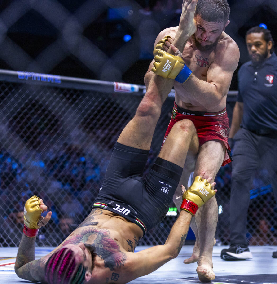 Sean O'Malley attempts to kick away Merab Dvalishvili above him in their bantamweight title fig ...