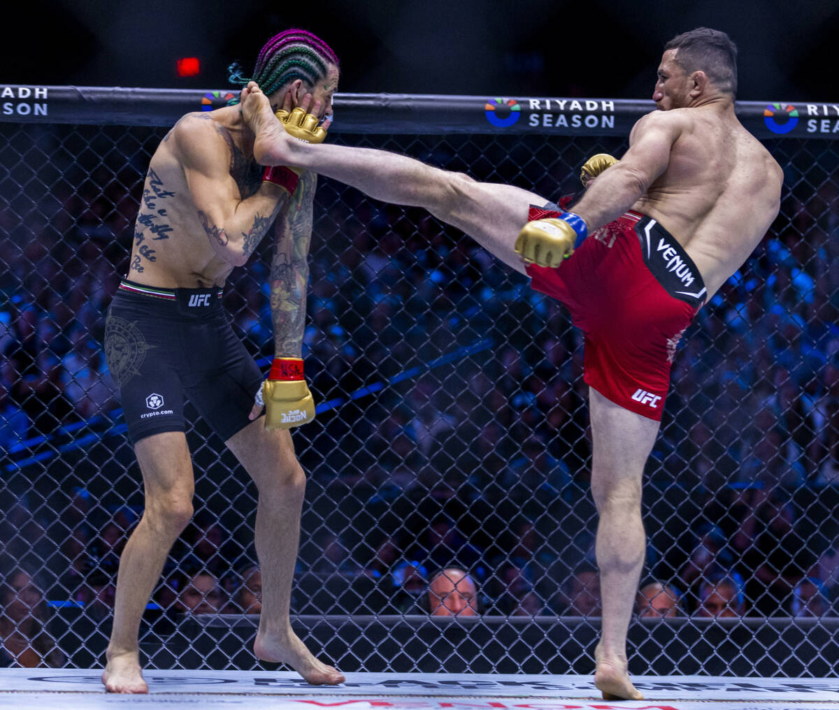 Sean O'Malley takes a kick to the face from Merab Dvalishvili in their bantamweight title fight ...