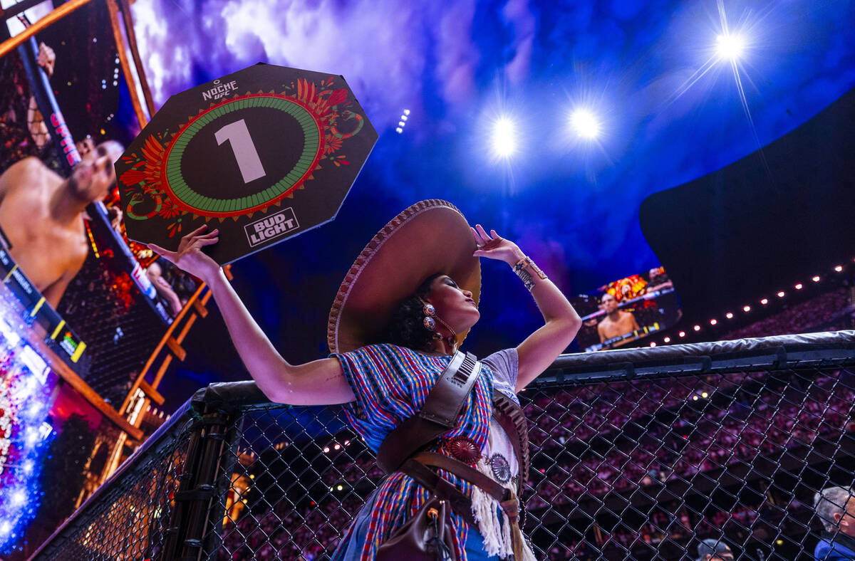 An octagon girl holds her round sign as Sean O'Malley faces Merab Dvalishvili in their bantamwe ...