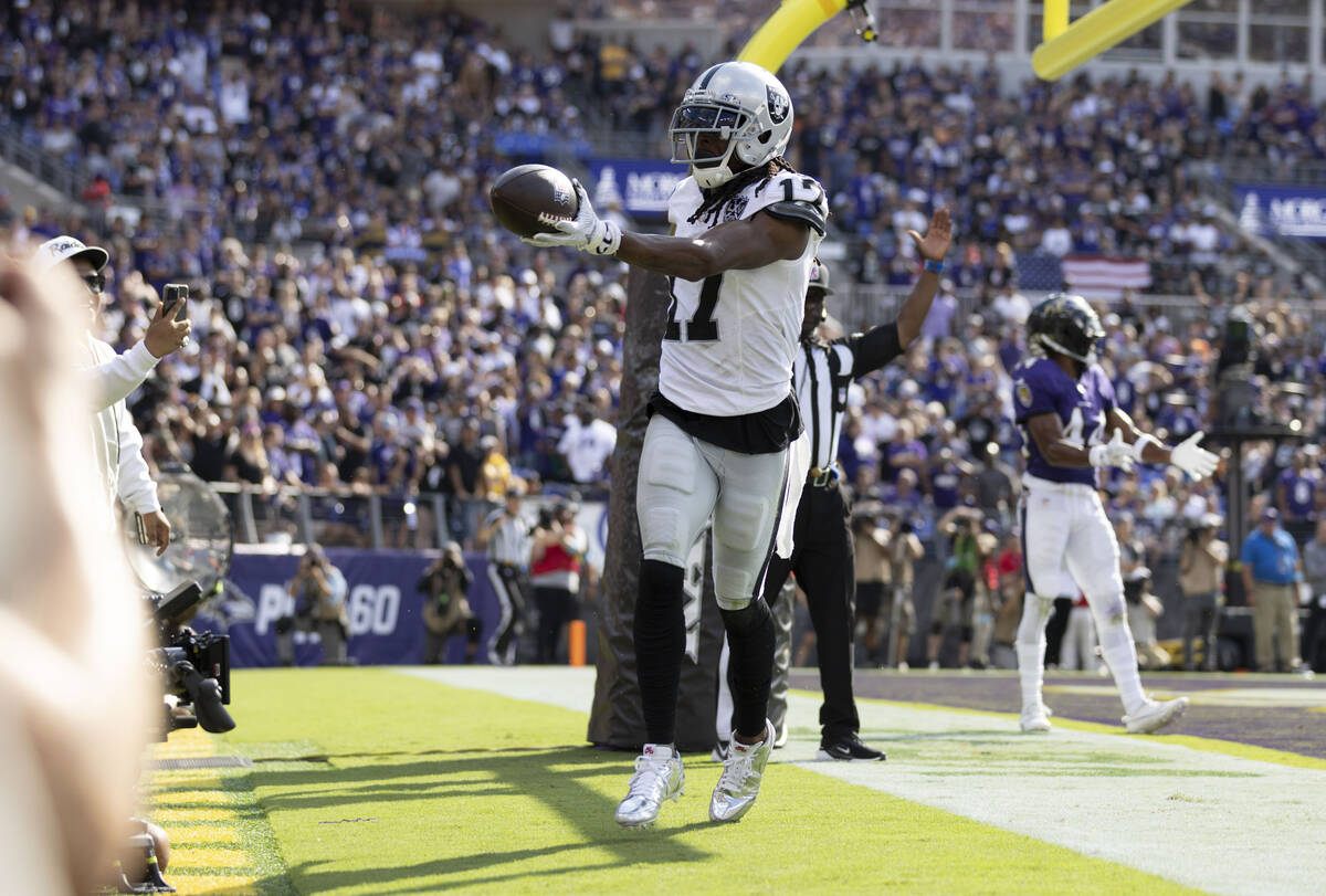 Raiders wide receiver Davante Adams (17) holds on to the football after scoring a touchdown dur ...