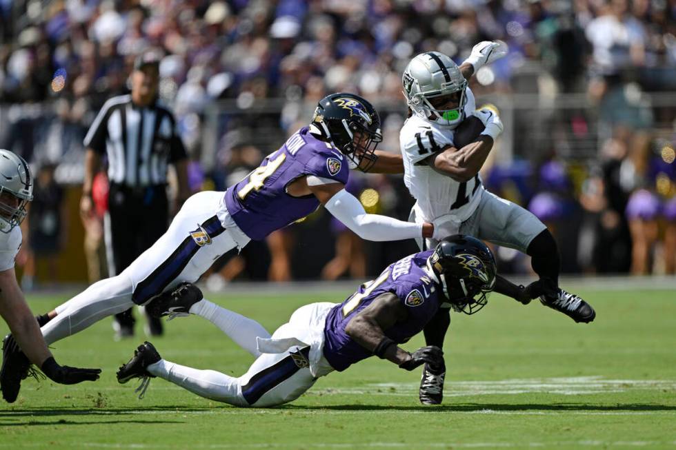 Las Vegas Raiders wide receiver Tre Tucker (11) runs with the ball after catching a pass and is ...