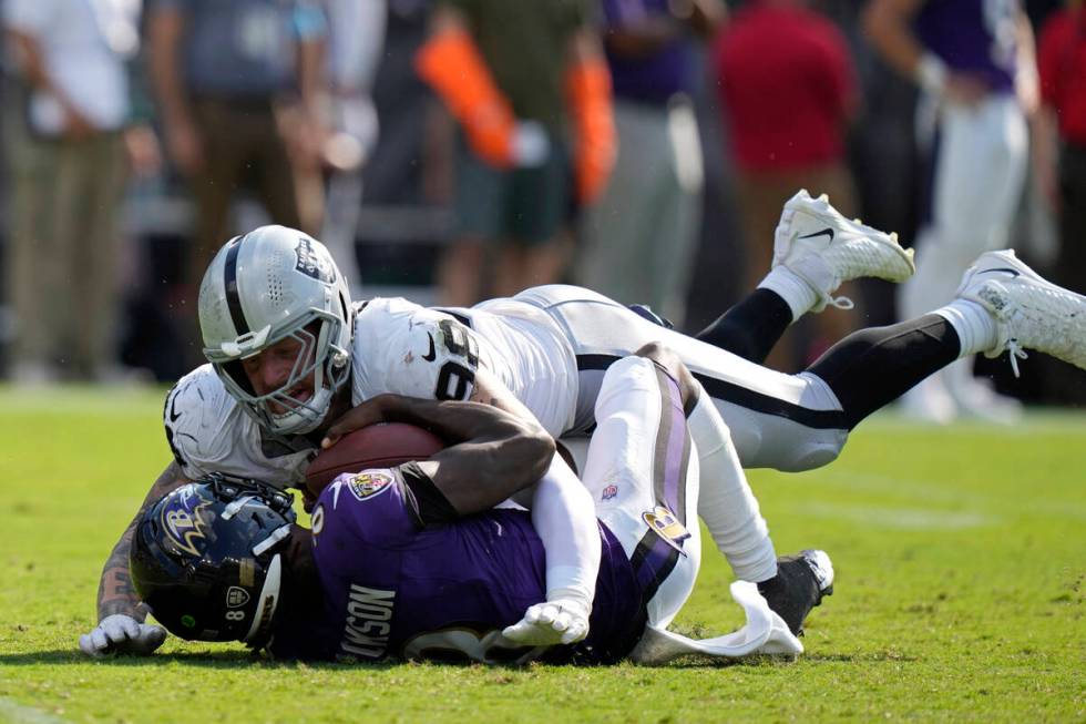 Las Vegas Raiders defensive end Maxx Crosby (98) sacks Baltimore Ravens quarterback Lamar Jacks ...