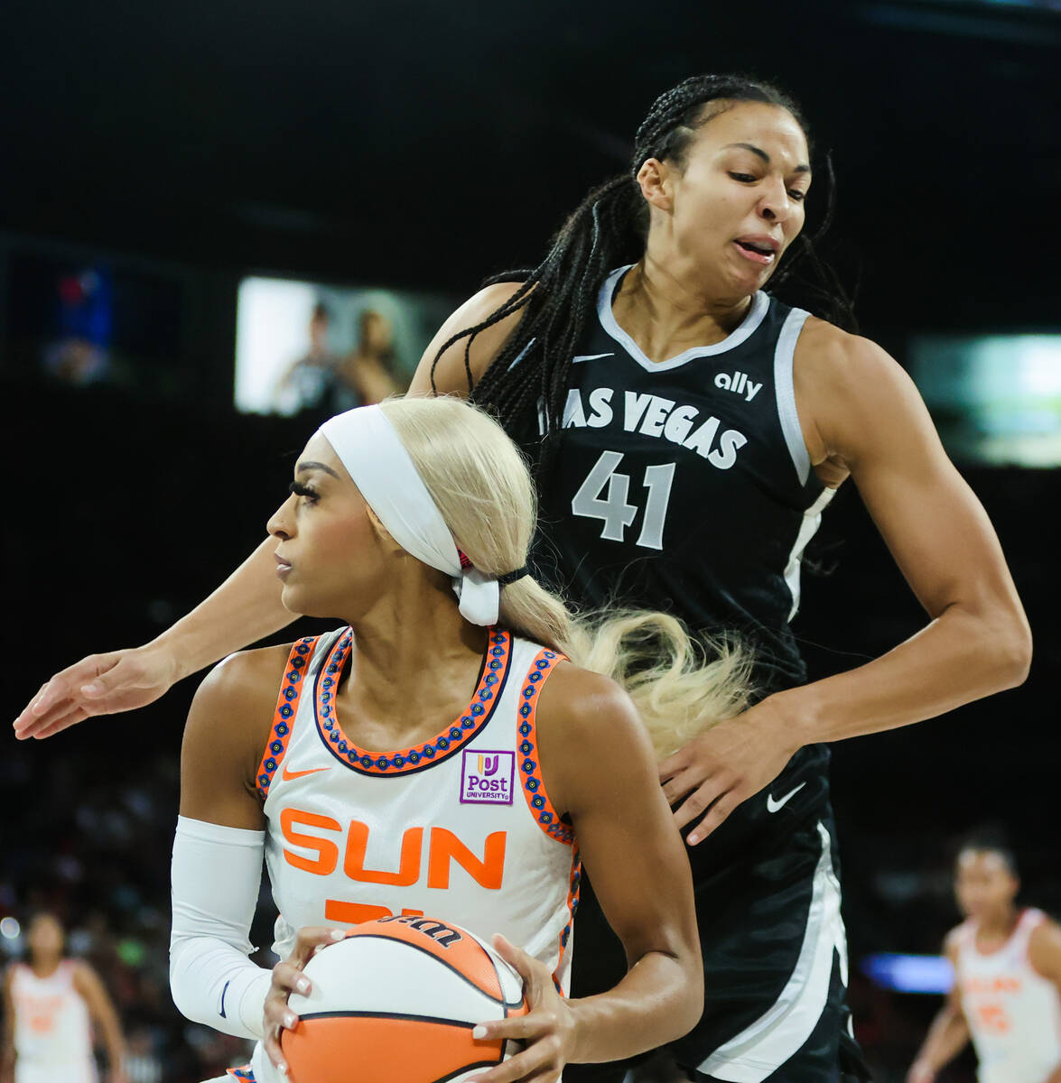 Connecticut Sun guard DiJonai Carrington (21) moves the ball as Aces center Kiah Stokes (41) gu ...