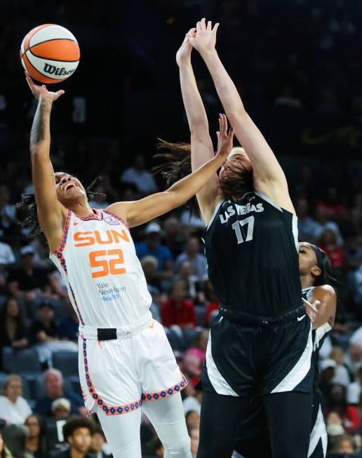 Connecticut Sun guard Tyasha Harris (52) fights to make a basket as she keeps Aces center Megan ...