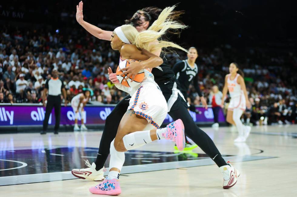 Connecticut Sun guard DiJonai Carrington (21) drives the ball past Aces center Megan Gustafson ...