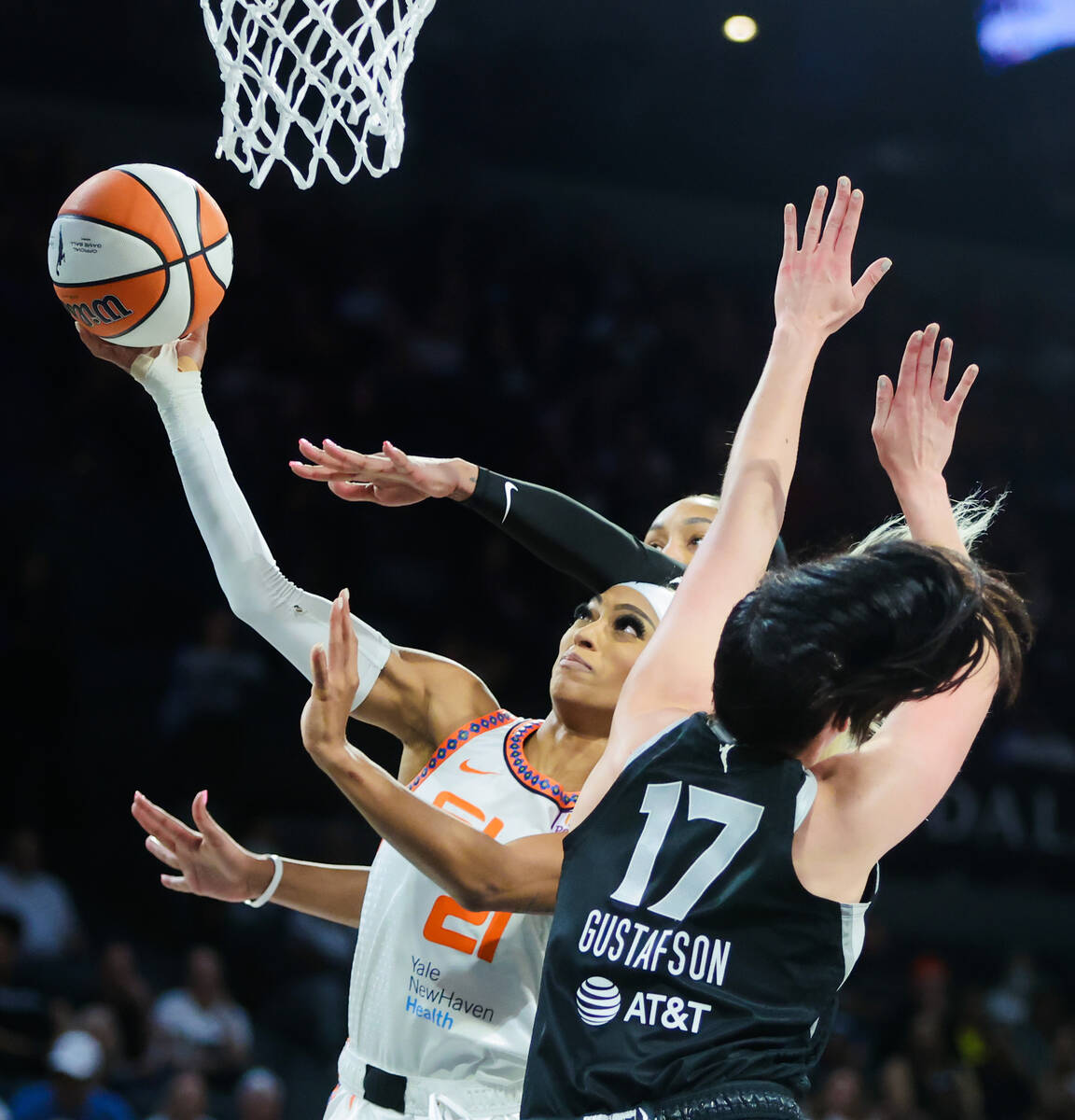 Connecticut Sun guard DiJonai Carrington (21) reaches for a basket as Aces center Megan Gustafs ...