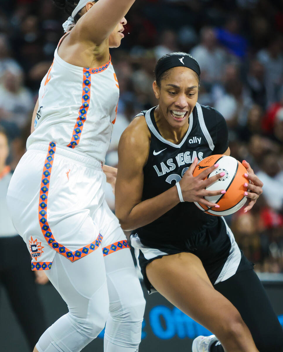 Aces center A'ja Wilson (22) fights to move the ball across the paint during a WNBA basketball ...