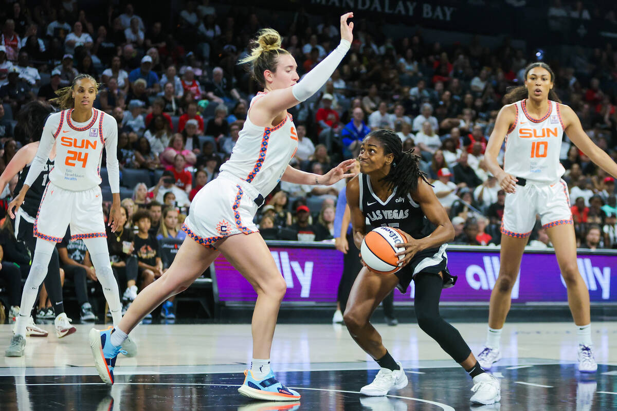 Aces guard Tiffany Hayes (15) looks to make a basket as Connecticut Sun guard Marina Mabrey (4) ...