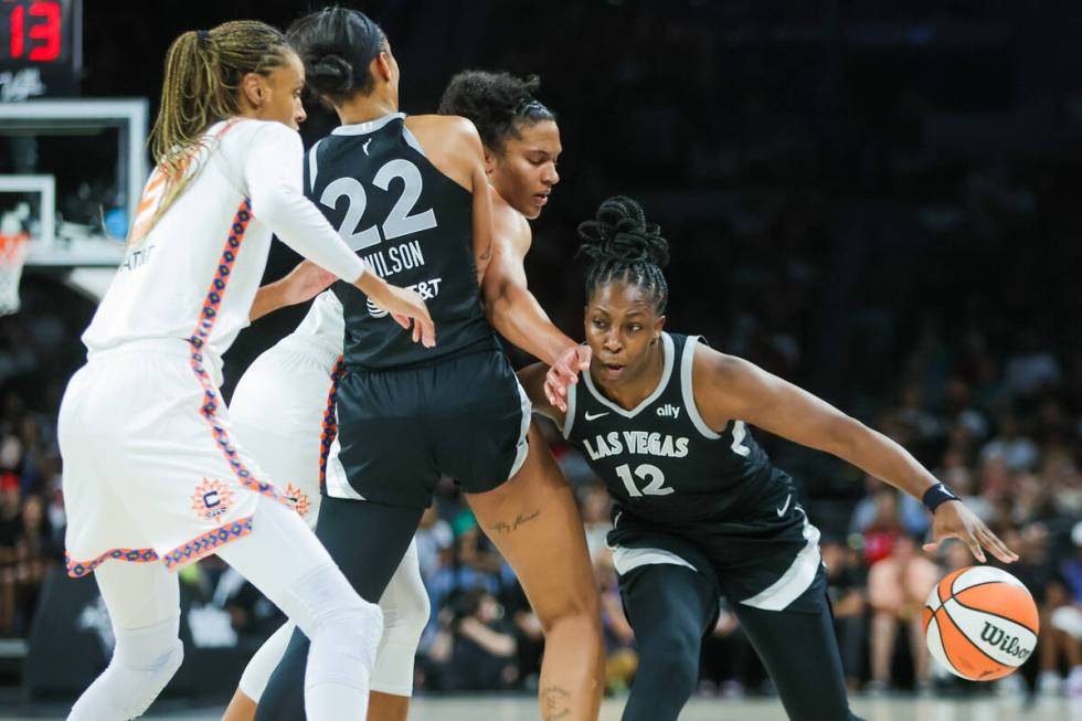 Aces guard Chelsea Gray (12) drives the ball past Connecticut Sun defenders during a WNBA baske ...