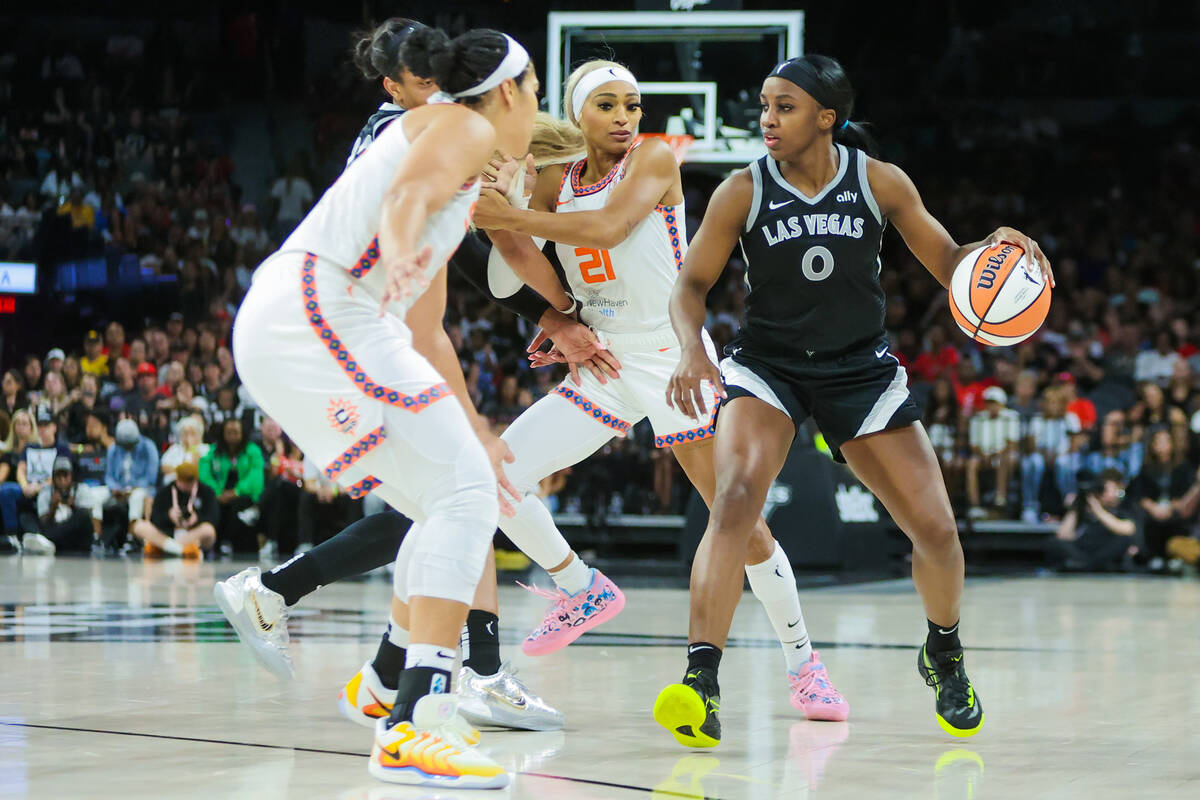 Aces guard Jackie Young (0) dribbles the ball past Connecticut Sun defenders during a WNBA bask ...