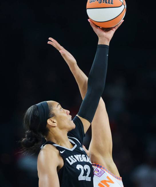 Aces center A'ja Wilson (22) reaches for the ball during tip off at a WNBA basketball game betw ...