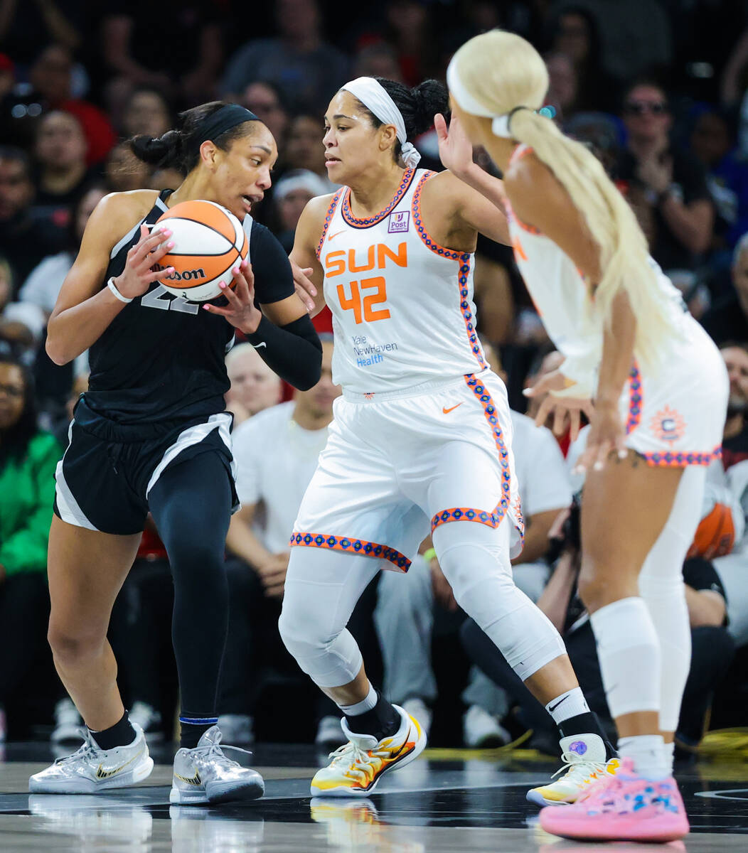 Aces center A'ja Wilson (22) tries to move the ball past Connecticut Sun forward Brionna Jones ...