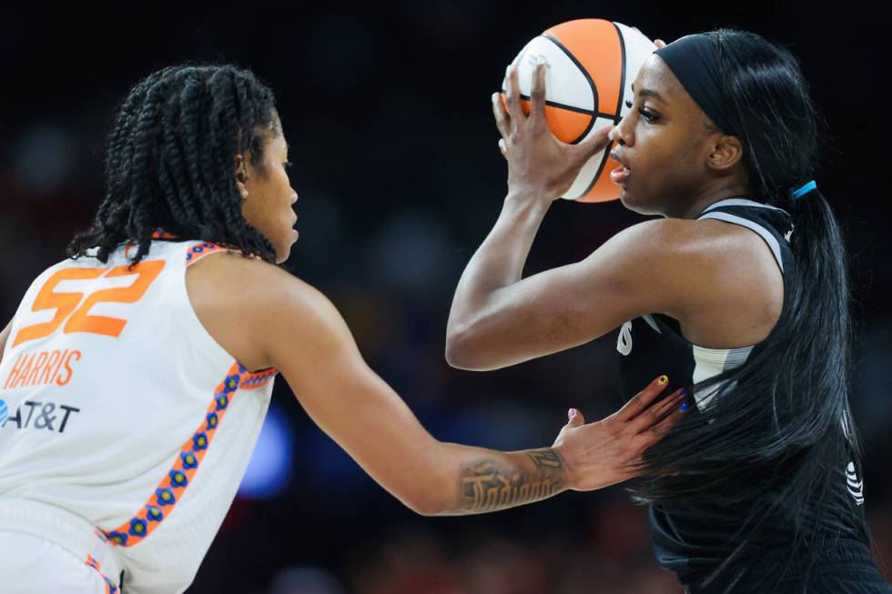 Aces guard Jackie Young (0) looks for a teammate to pass the ball to as Connecticut Sun guard T ...