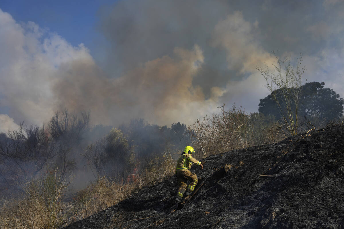 A firefighter works in the area around a fire after the military said it fired interceptors at ...