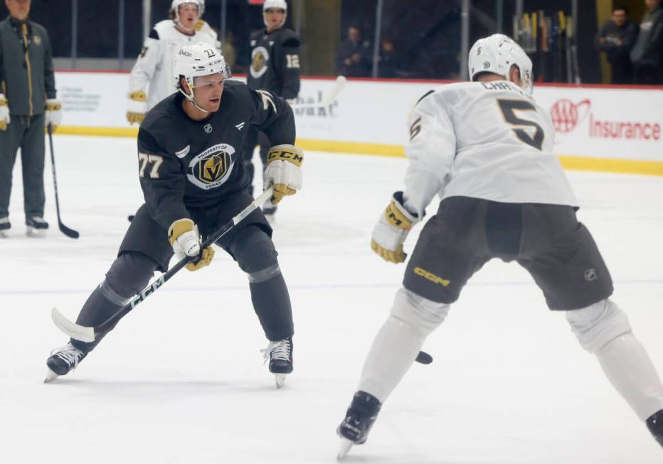 Golden Knights forward Kai Uchacz (77) passes the puck as defenseman Daniil Chayka (5) looks on ...