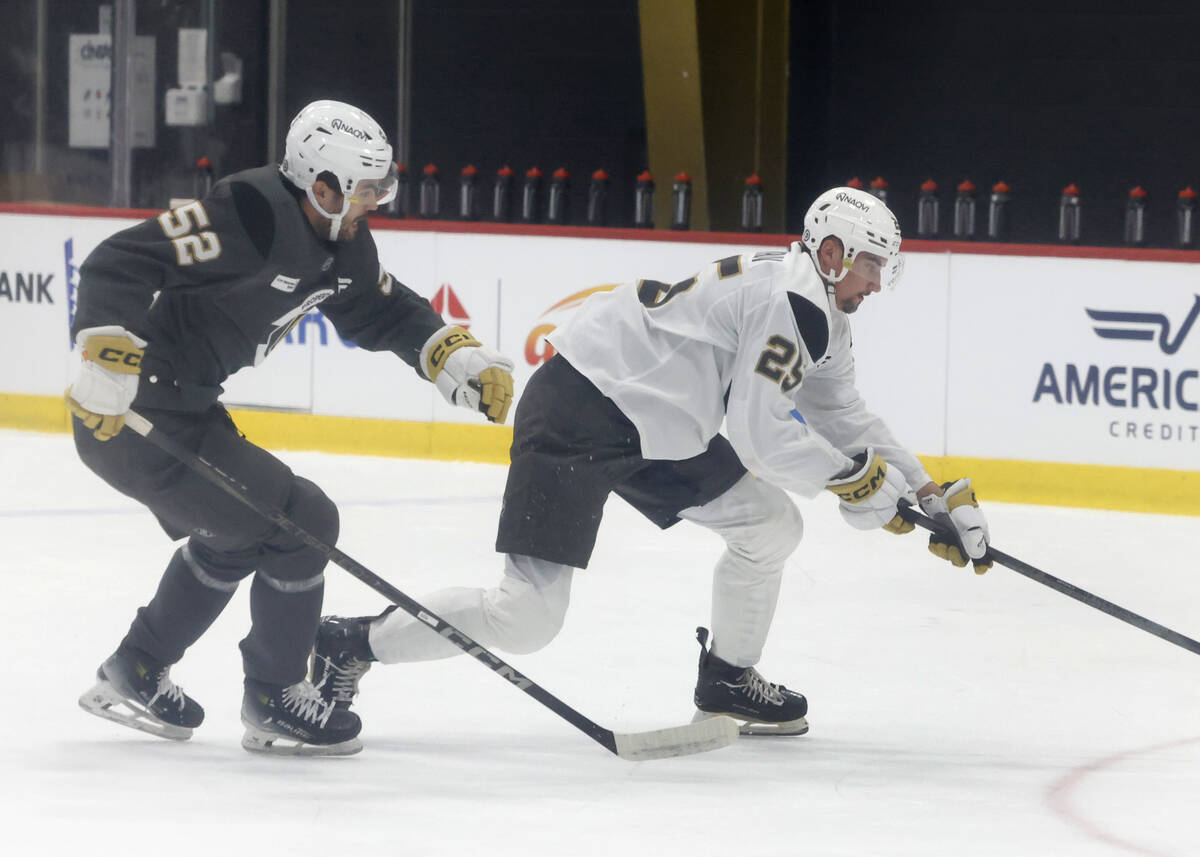 Golden Knights defenseman Artur Cholach (52) and forward Matyas Sapovaliv (25) battle for a loo ...